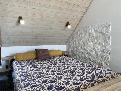 une chambre avec un lit avec un mur en pierre dans l'établissement 661 - Charmante maison en pierre sur les Hauteurs d'Erquy avec vue mer, à Erquy