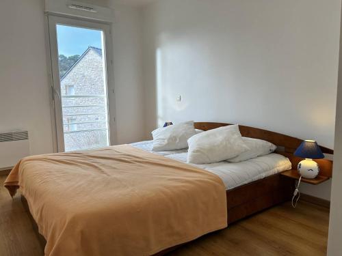 un lit dans une chambre avec une grande fenêtre dans l'établissement 531 - Appartement T2 vue mer, à 100m de la Plage, à Erquy