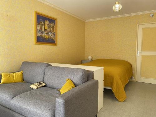 un salon avec un canapé et un lit dans l'établissement 533 - Appartement T1 situé à quelques pas de la grande plage d'Erquy et du centre, à Erquy