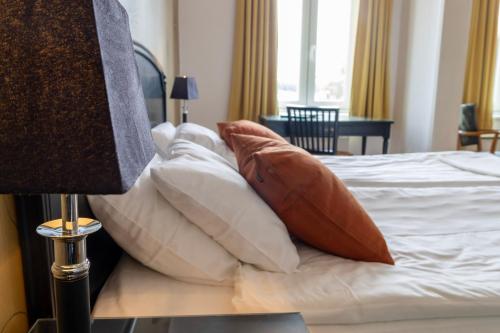 a pile of pillows sitting on top of a bed at Möckelsnäs Herrgård in Diö