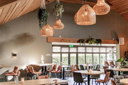 a restaurant with tables and chairs and pendant lights at Enterbrook in Enter