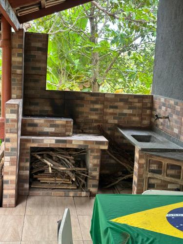 eine Terrasse mit einem gemauerten Kamin und einem Waschbecken in der Unterkunft Chácara Recanto da Paz in Caldas Novas
