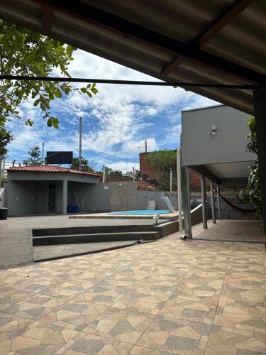 a patio with a swimming pool and a building at Chácara Recanto da Paz in Caldas Novas