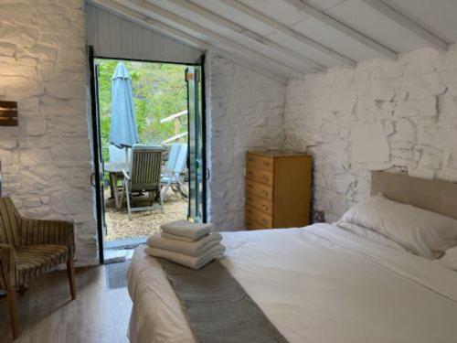 una camera da letto con un letto e un patio con un ombrellone di The Old Workshop a New Mills