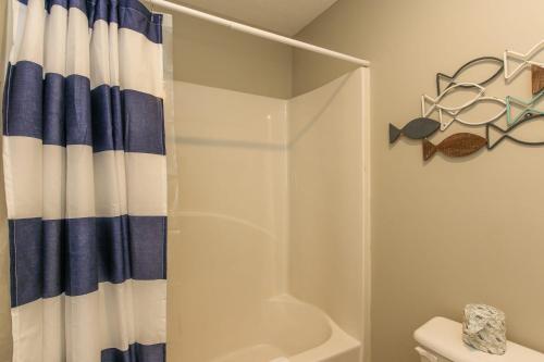 a bathroom with a shower with a blue and white shower curtain at House #04 - Happy Camper-(No Pets) -Private Pier in Centre