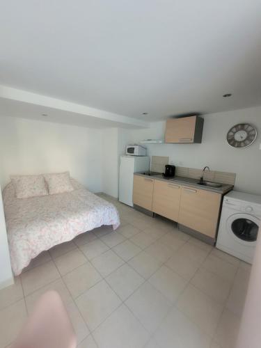 une petite chambre avec un lit et une cuisine dans l'établissement Studio Corbas, à Corbas