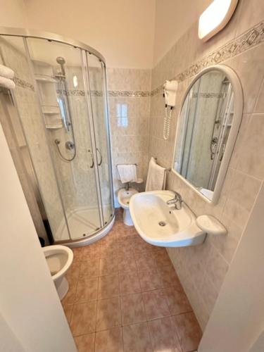 een badkamer met een wastafel, een douche en een toilet bij Hotel Fiorenza in Milano Marittima