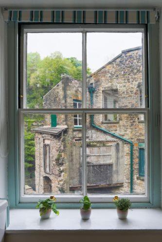a window with a view of an old building at The Manager's Suite in New Mills
