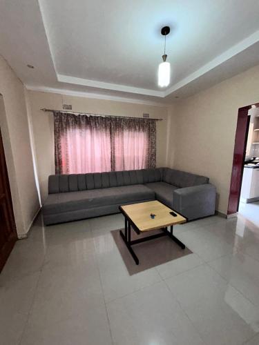 a living room with a couch and a coffee table at Tranquil Room in Apartment in Lusaka