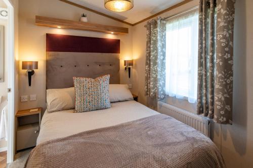 een slaapkamer met een bed en een groot raam bij Abingdon Lodge 7 Close to St Andrews in Strathkinness