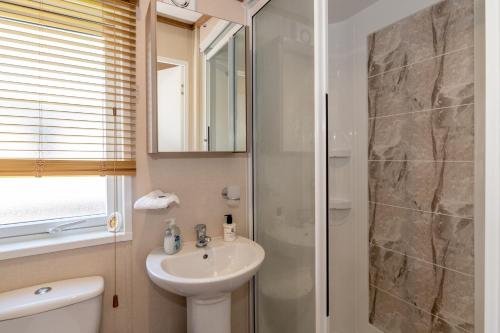 La salle de bains est pourvue d'un lavabo et d'une douche. dans l'établissement Abingdon Lodge 7 Close to St Andrews, à Strathkinness