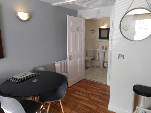 une chambre avec une table et des chaises et une salle de bain dans l'établissement The Bath House Apartments - Free 1st breakfast - FREE parking, à Bath