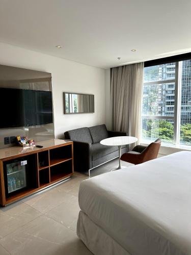 Habitación de hotel con cama, TV y sofá en Hotel Nacional RJ apto 504, en Río de Janeiro