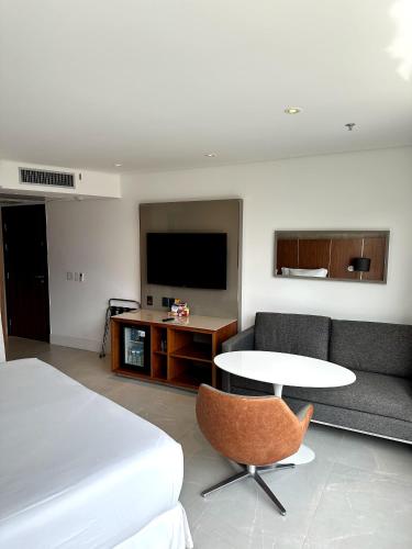 Habitación con cama, mesa y sofá en Hotel Nacional RJ apto 504, en Río de Janeiro