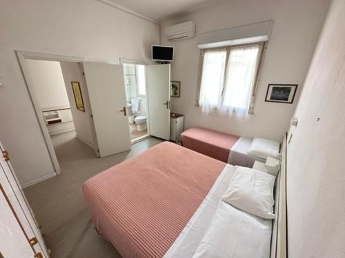 a bedroom with two beds and a room with a window at Hotel Fiorenza in Milano Marittima