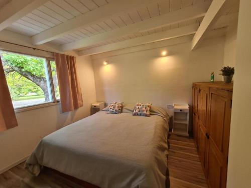 a bedroom with a bed with two pillows and a window at Linaje Hotel Boutique & Relax in Lago Puelo
