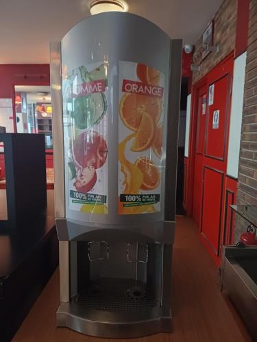 a vending machine with orange juice in a store at Hotel Joinville Hippodrome in Joinville-le-Pont