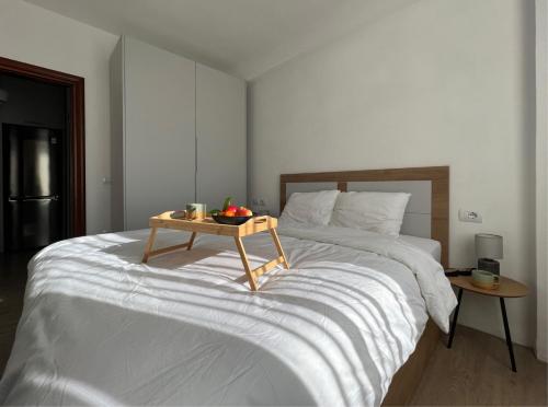 ein Bett mit einem hölzernen Tablett darüber in der Unterkunft Cherry Apartment in Durrës