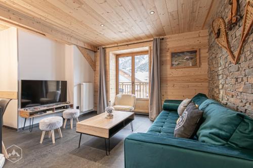 泰爾米尼翁的住宿－"Le Temps Suspendu"，客厅配有绿色沙发和电视
