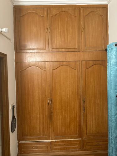 a large wooden cabinet in the corner of a room at Singh villa in Mohali