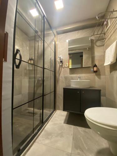 a bathroom with a glass shower and a sink at Kadıköy Linda Hotel in Istanbul