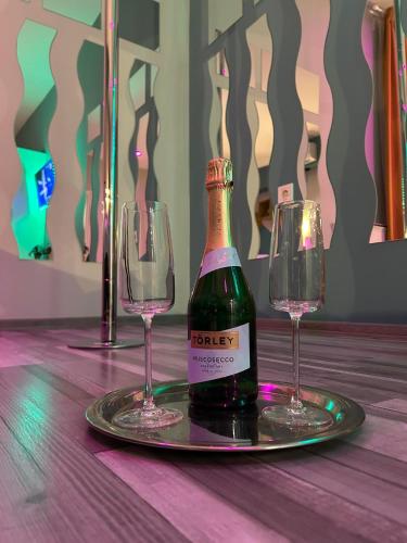 a bottle of champagne and two wine glasses on a table at 7 days Apartment in Makó