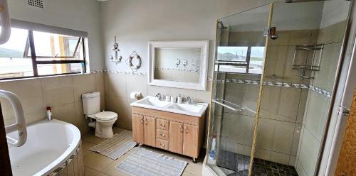 a bathroom with a shower and a sink and a toilet at Ankervas in Morganʼs Bay