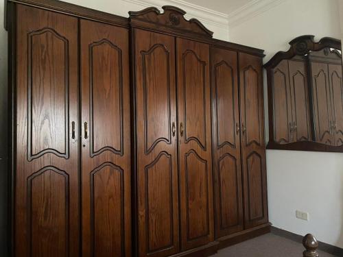 un montón de armarios de madera en una habitación en Iyad apartment en Amán