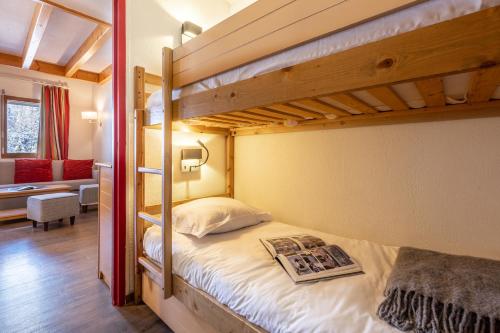 a bedroom with two bunk beds with a magazine on it at Résidence Pierre & Vacances Les Ravines in Méribel