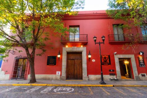 un edificio rojo con una puerta de madera en una calle en Hotel Boutique Naura Centro en Oaxaca de Juárez