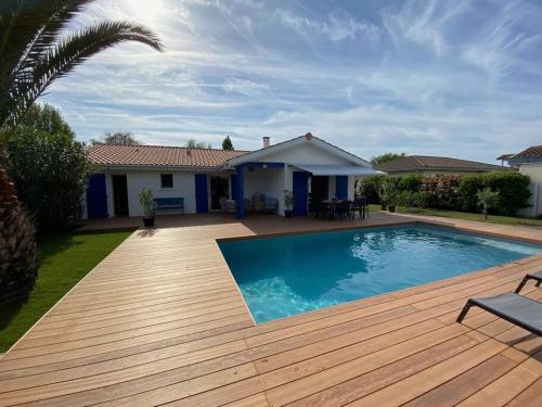 une cour arrière avec une piscine et une maison dans l'établissement Maison moderne avec piscine, à La Teste-de-Buch