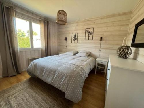 a bedroom with a bed and a desk in it at Maison moderne avec piscine in La Teste-de-Buch