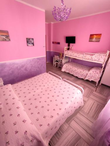 a bedroom with two bunk beds and pink walls at Hotel Serenella in Turin
