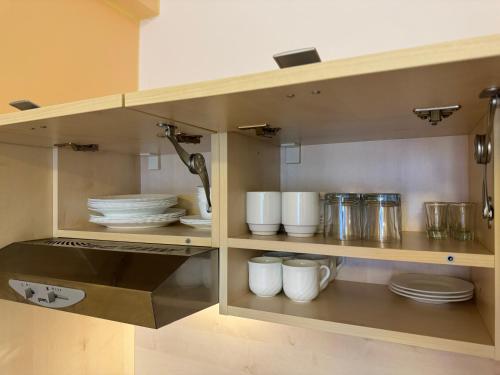 a cupboard with plates and other dishes in it at Apartment 416 with mountain view in Hotel Crocus, Strbske Pleso in Štrbské Pleso