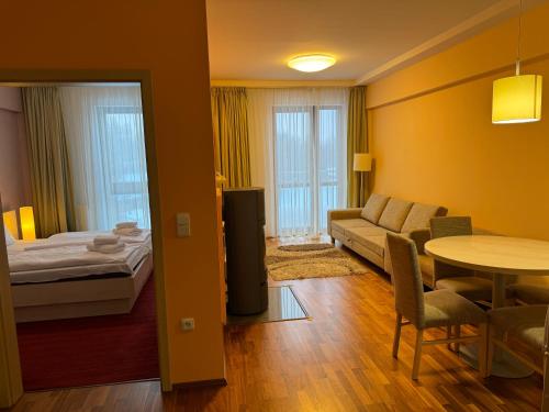 a living room with a couch and a bed and a table at Apartment 416 with mountain view in Hotel Crocus, Strbske Pleso in Štrbské Pleso