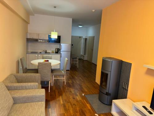 a living room with a couch and a table and a kitchen at Apartment 416 with mountain view in Hotel Crocus, Strbske Pleso in Štrbské Pleso