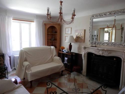 - un salon avec une chaise et une cheminée dans l'établissement Gîte du Theil, en campagne, à Lépinas