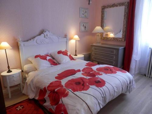 une chambre avec un lit avec des fleurs rouges dessus dans l'établissement Gîte du Theil, en campagne, à Lépinas