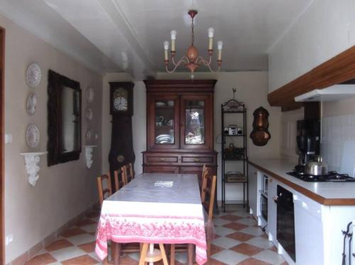 une salle à manger avec une table et une cuisine dans l'établissement Gîte du Theil, en campagne, à Lépinas