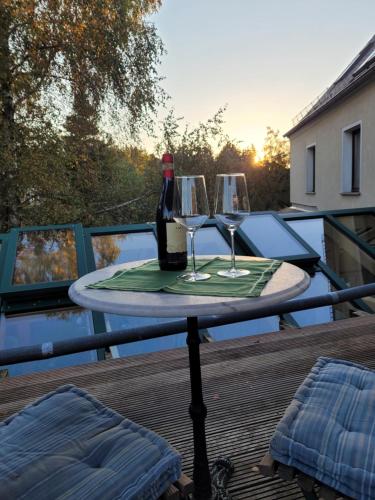 a table with two glasses and a bottle of wine at FeWo Weitblick in Höhenlage von Greiz in Greiz