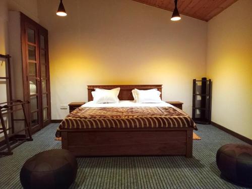 a bedroom with a large bed with two pillows at Aquaa Leaf Residences in Nuwara Eliya