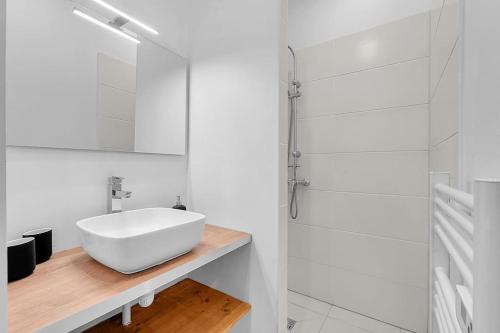 y baño blanco con lavabo y ducha. en Le Cocon - T2 Cosy hypercentre avec parking, en Toulouse