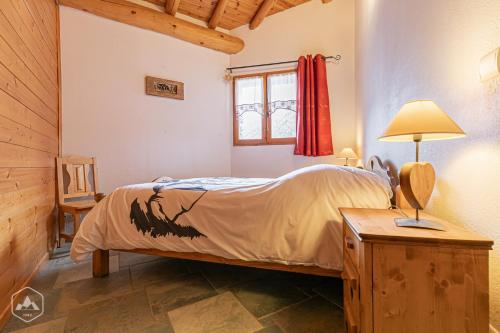 ein Schlafzimmer mit einem Bett und einem Tisch mit einer Lampe in der Unterkunft "L'Ancolie" Appartement de Charme 4 Personnes à Val Cenis in Termignon