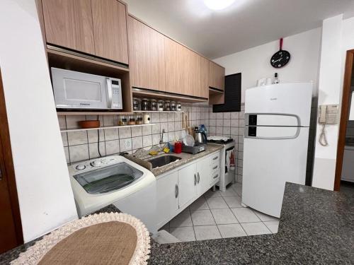 una cucina con frigorifero bianco e lavandino di Apartamento beira mar a Florianópolis