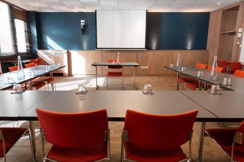 a conference room with tables and chairs and a screen at ibis Lyon Centre Perrache in Lyon