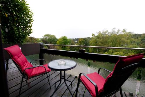 een balkon met een tafel en stoelen en een tafel bij Romantik Parkhotel am Hammerberg in Stolberg