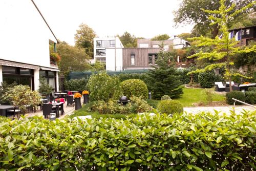a garden in front of a building with bushes at Parkhotel Hammerberg in Stolberg