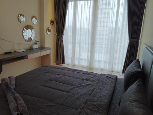 a bedroom with a bed and a large window at MESA Thamrin City Apartments at Nagoya with Netflix & Pick Up Service in Nagoya