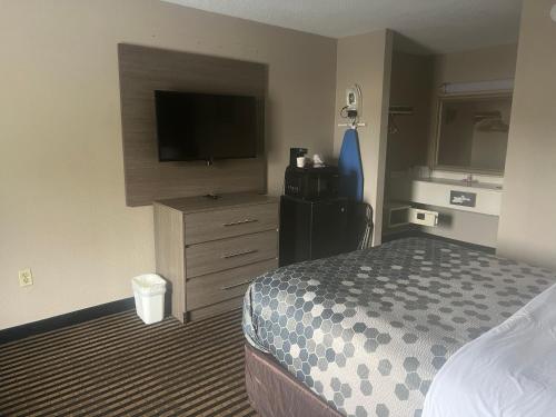 a hotel room with a bed and a flat screen tv at Econo Lodge Florence - Darlington in Florence