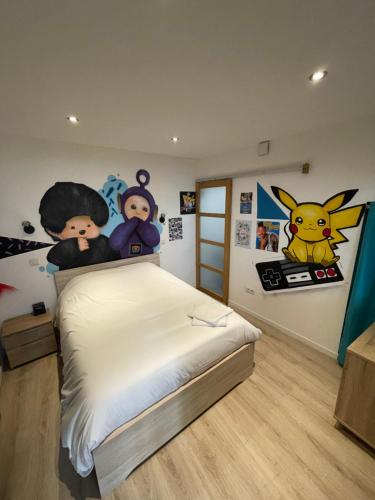 een slaapkamer met een bed met stripfiguren erop bij Le 90'S in Tulle